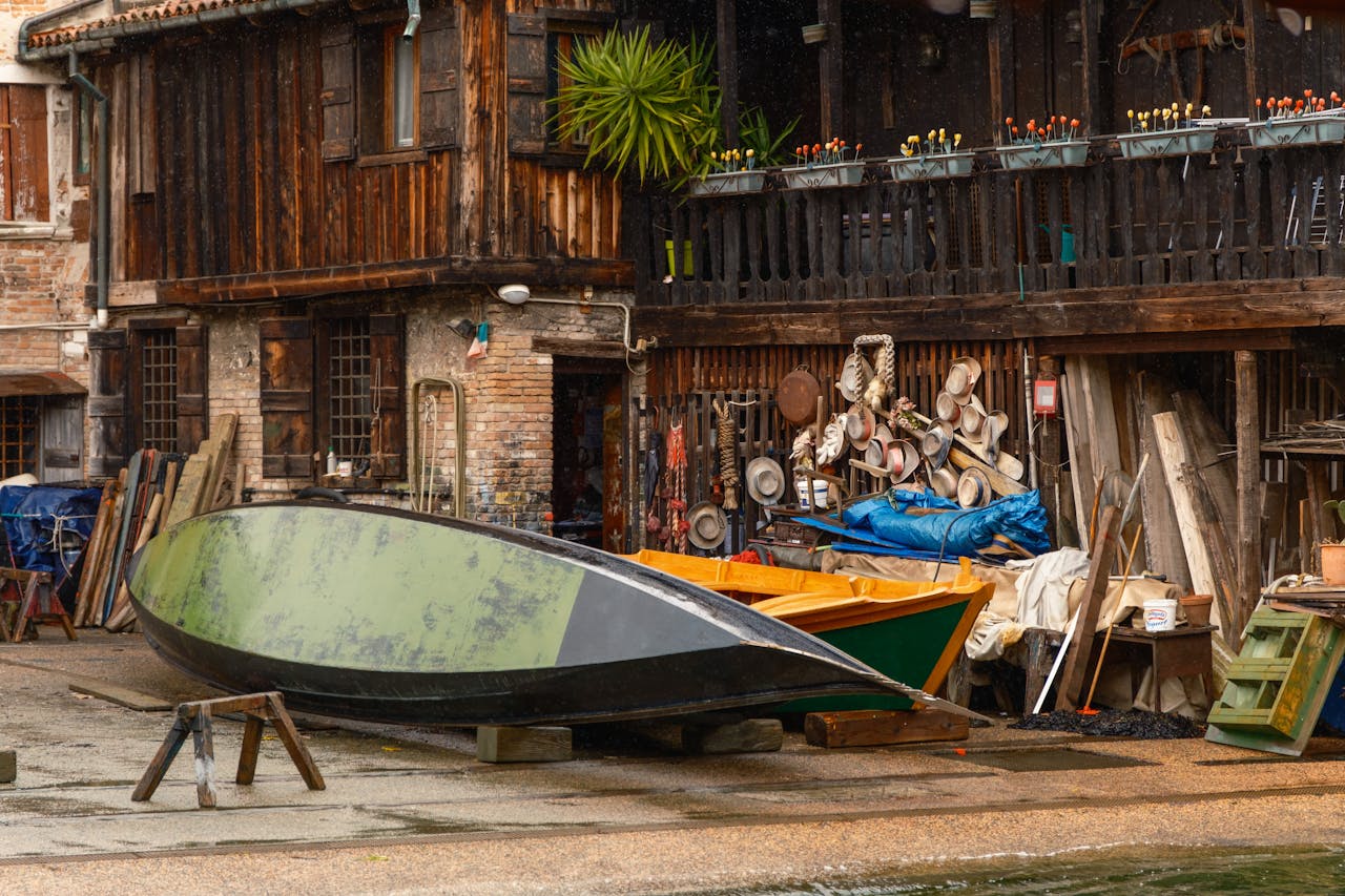 A classic wooden boat workshop with tools and hats in Venice, Italy.